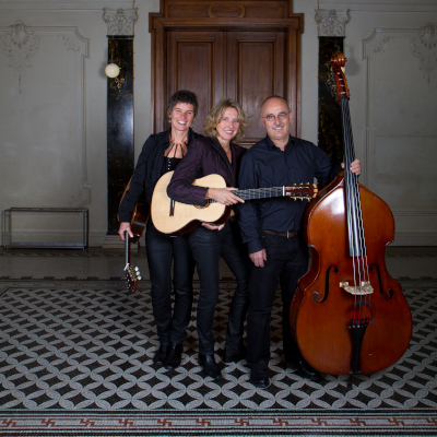 TrioAngeluci mit Instrumenten in Säulengang vor einer Tür